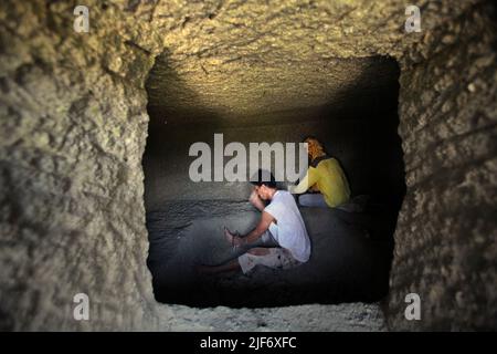 Operai che scavano e intagliano attraverso la roccia per costruire una camera per la tomba tradizionale camera di pietra a Nord Toraja, Sulawesi Sud, Indonesia. Foto Stock