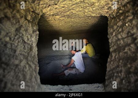 Operai che scavano e intagliano attraverso la roccia per costruire una camera per la tomba tradizionale camera di pietra a Nord Toraja, Sulawesi Sud, Indonesia. Foto Stock