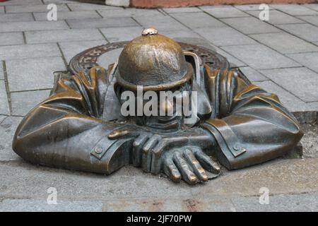 Bratislava, Slovacchia - 19 aprile 2012: Famosa statua di Cumil, un operaio fognario che esce da un tombino. Scultura cittadina Foto Stock