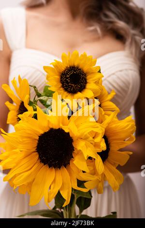 Bouquet di girasoli nelle mani della sposa Foto Stock