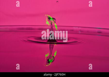 Macro aufnahme Wasser Wassertropfen Wassertropfen kollision rot grün magenta wie Atompilz, che collidono goccioline d'acqua che assomiglia a nube di funghi Foto Stock