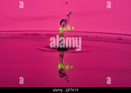 Macro aufnahme Wasser Wassertropfen Wassertropfen kollision rot grün magenta wie Atompilz, che collidono goccioline d'acqua che assomiglia a nube di funghi Foto Stock