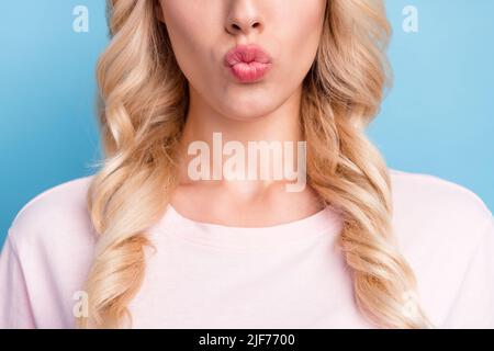 Donna fotografica ritagliata con capelli biondi ricci che inviano aria bacio isolato pastello blu sfondo colore Foto Stock