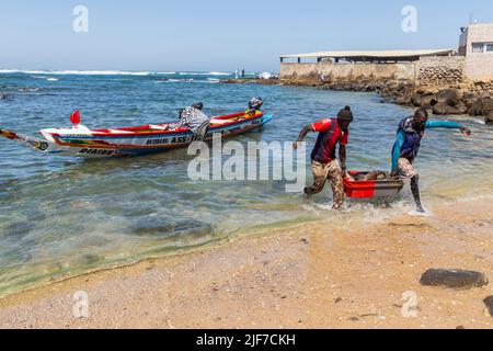 Dakar, Senegal. 18 agosto 2019: Pescatori con una barca da pesca in una spiaggia a Dakar, una delle molte spiagge di pesca di Dakar, Senegal, Africa occidentale Foto Stock