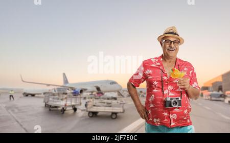 Buon turista maschio maturo che posa su un grembiule aeroporto Foto Stock