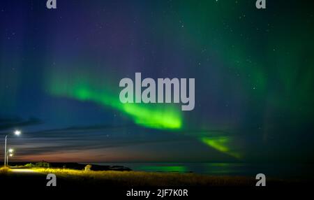 Aurora boreale su un fiordo nella remota est dell'Islanda Foto Stock