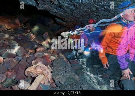 Gruppo di scienziati che esplorano la grotta di lava di Leidarendi in Islanda Foto Stock