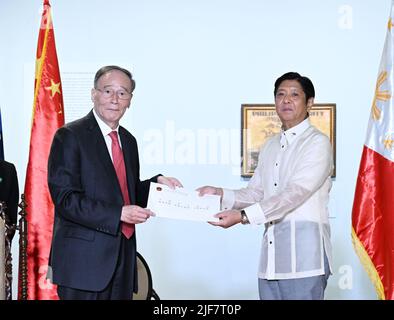 Manila, Filippine. 30th giugno 2022. Il vicepresidente cinese Wang Qishan consegna una lettera di congratulazioni dal presidente cinese Xi Jinping al presidente filippino Ferdinand Romualdez Marcos durante il loro incontro a Manila, nelle Filippine, il 30 giugno 2022. Come rappresentante speciale del presidente cinese Xi Jinping, Wang ha partecipato all'inaugurazione presidenziale filippina di Ferdinand Romualdez Marcos giovedì su invito del governo delle Filippine. Credit: Zhang Ling/Xinhua/Alamy Live News Foto Stock