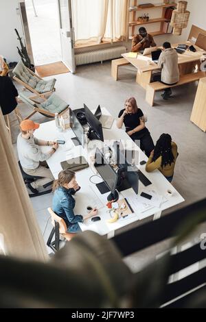 Visualizzazione ad angolo elevato dei colleghi aziendali in fase di avvio che lavorano insieme in ufficio Foto Stock