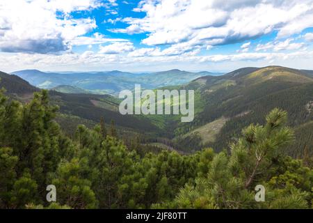 Una valle corre tra le montagne alla sezione trasversale dei pendii, formata da forti ruscelli, che nel tempo hanno tagliato nella roccia attraverso un pr Foto Stock