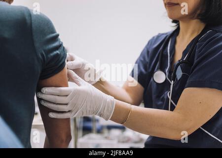 Sezione centrale del ginecologo femminile indossando guanti protettivi che esaminano il paziente in clinica medica Foto Stock