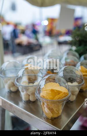 spuntini per birra in confezioni di plastica, patatine in tazza. Foto Stock