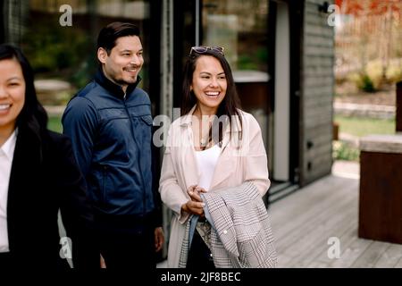 Coppia felice in piedi da venditore fuori casa Foto Stock
