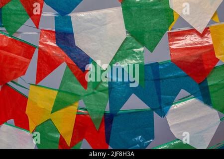 Goiania, Goiás, Brasile – 30 giugno 2022: Diversi pennanti colorati appesi sulla clothesline con il cielo blu sullo sfondo alla festa di giugno. Foto Stock