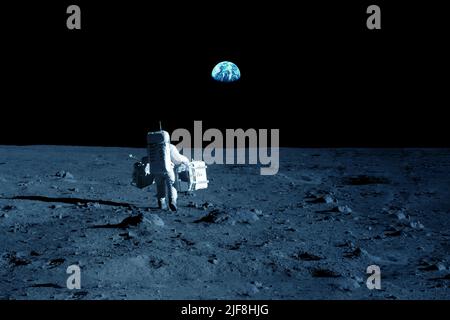 Astronauta sulla luna, con la Terra sullo sfondo. Elementi di questa immagine forniti dalla NASA. Foto di alta qualità Foto Stock