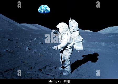 Astronauta sulla luna, con la Terra sullo sfondo. Elementi di questa immagine forniti dalla NASA. Foto di alta qualità Foto Stock
