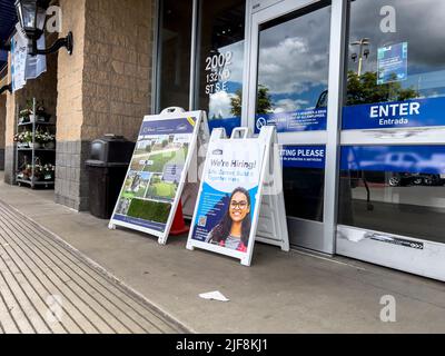 Mill Creek, WA USA - circa Giugno 2022: Vista ad angolo di un segno Now Hiring fuori dell'ingresso al negozio di miglioramento casa Lowe. Foto Stock