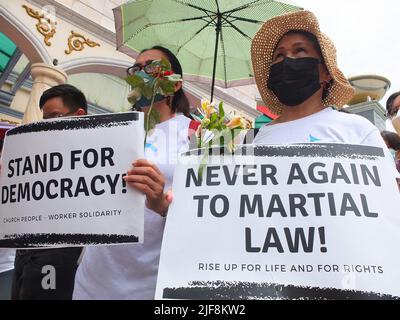 Manila, Filippine. 30th giugno 2022. Le donne tengono rose e cartelli durante la dimostrazione. I gruppi militanti hanno organizzato una protesta a Plaza Miranda a Quiapo nella Giornata di inaugurazione del Presidente eletto Ferdinand 'Bongbong' Marcos Jr. L'ordine del giorno principale della protesta è stato quello di chiedere la responsabilità da parte dell'amministrazione entrante per le richieste dell'economia e i crimini commessi sotto la dittatura del Late Ferdinand Marcos Sr. (Photo by Josefiel Rivera/SOPA Images/Sipa USA) Credit: Sipa USA/Alamy Live News Foto Stock