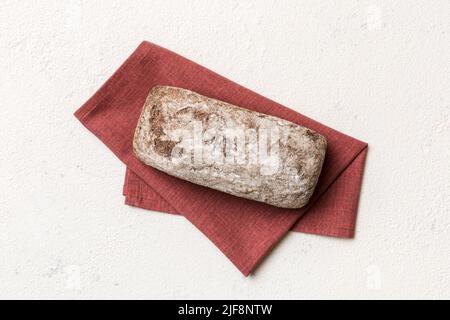 Pane fresco di segale su tovagliolo su sfondo rustico, vista dall'alto del pane fresco. Foto Stock