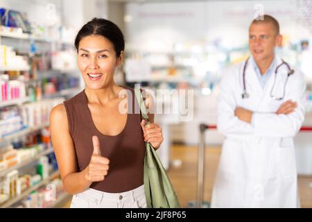 Ritratto di una donna cliente sorridente felice con il servizio in farmacia moderna Foto Stock