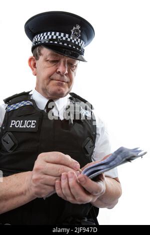 Un poliziotto britannico in uniforme che prende appunti nel suo blocco note. Parte di una serie di immagini con lo stesso modello di carattere. Foto Stock