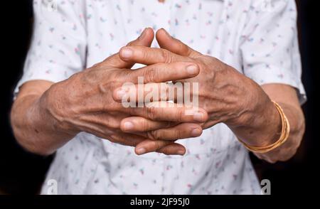 Mani della donna anziana del sud-est asiatico. Concetto di artrite reumatoide, osteoartrite, o dolore articolare. Foto Stock