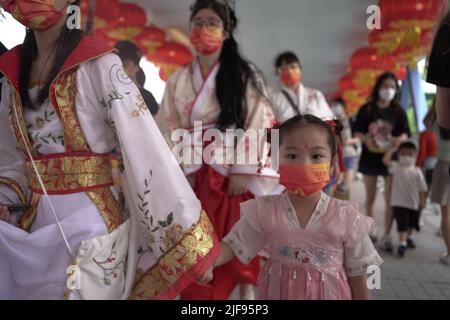 Un bambino tra una processione di gente che celebra la cerimonia di consegna di Hong Kongs con bandiere cinesi. XI Jinping, il leader cinese, si trova nella città della RAS per partecipare alla cerimonia del 25th, così come al giuramento del nuovo amministratore delegato di Hong Kongs, John Lee Foto Stock
