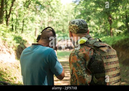 Un uomo civile ucraino si sta allenando per sparare una mitragliatrice AKM durante la guerra dell'Ucraina con la Russia Foto Stock