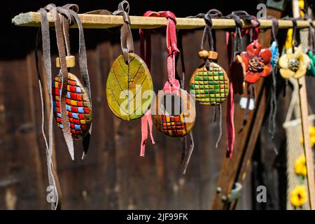 Gruppo di collane colorate dipinte a mano e di souvenir esposti in vendita in un tradizionale mercato del fine settimana a Bucarest, Romania Foto Stock