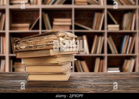 Pila di vecchi libri sul tavolo in biblioteca Foto Stock