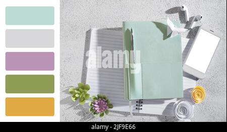 Notebook, telefono cellulare, auricolari e origami su sfondo chiaro. Diversi motivi di colore Foto Stock