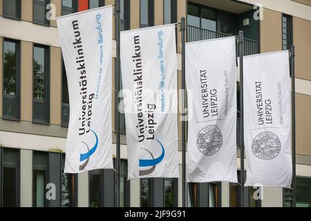 Lipsia, Germania. 01st luglio 2022. Le bandiere dell'Università di Lipsia e dell'Ospedale Universitario si trovano di fronte a uno degli edifici dell'ospedale. Lo stesso giorno, l'Ufficio di controllo statale della Sassonia presenta il primo volume della sua relazione annuale per quest'anno. In esso, attestano che gli ospedali universitari di Dresda e Lipsia presentano un notevole divario di investimenti. Credit: Jan Woitas/dpa/Alamy Live News Foto Stock