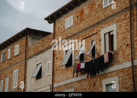 Asciugando i vestiti sulla facciata. Stile di vita cittadino in Italia. Foto Stock