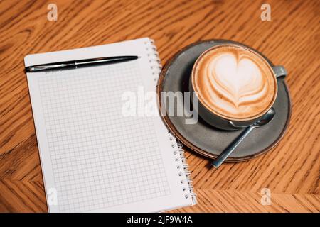 Una tazza di cappuccino è sul tavolo in un caffè Foto Stock