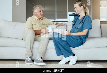 Un uomo e una donna sorridenti felici che mostrano il legame tra paziente e medico durante un controllo a casa. Un medico mostrante il supporto per il suo paziente mentre Foto Stock