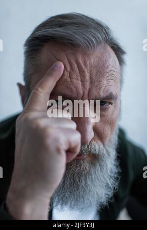 ritratto di uomo anziano triste toccando rughe e sofferenza crisi Foto Stock