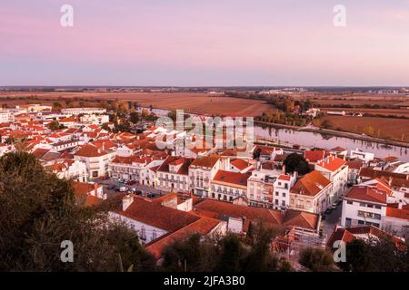 Bella vista sul centro del villaggio di Coruche in Portogallo, al tramonto, con il fiume Sorraia e i campi agricoli sullo sfondo. Foto Stock
