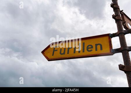 Segno giallo con iscrizione Furillen, cartello in ferro arrugginito, cielo nuvoloso, Laerbro, riserva naturale di Furilden e santuario degli uccelli, Furillen Foto Stock