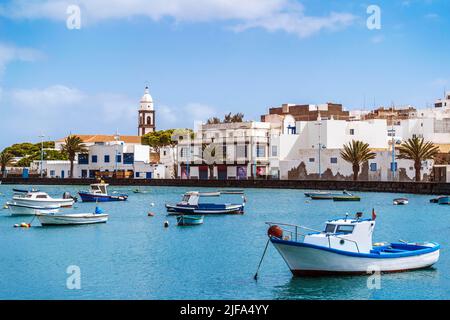 Bellissimo molo con architettura storica e barche sulle acque blu in Arrecife, Lanzarote, Isole Canarie, Spagna Foto Stock