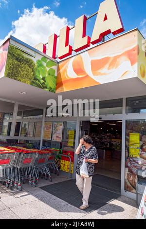 Donna anziana che lascia il supermercato Billa Foto Stock