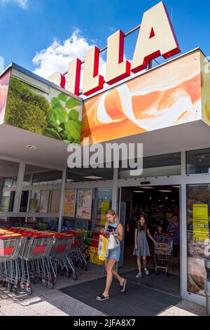 Giovane donna che lascia il supermercato Billa Foto Stock