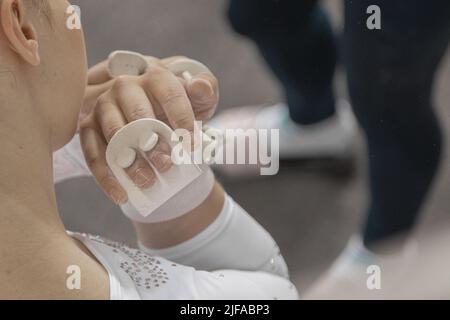 Impugnature o protezioni per la gara di ginnastica o ginnastica. Addon protettivi bianchi per dita o palmi utilizzati per competere in ginnastica. Foto Stock