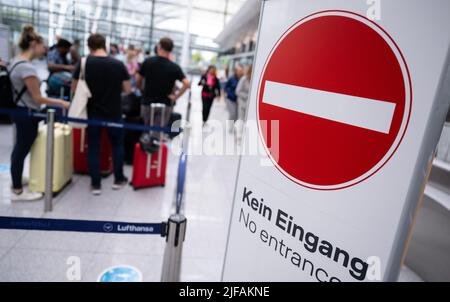 Monaco di Baviera, Germania. 01st luglio 2022. I passeggeri si trovano con i bagagli presso un banco check-in presso l'aeroporto di Monaco. Molti passeggeri sono ancora in attesa dei bagagli una settimana dopo la sosta all'aeroporto di Monaco. Credit: Sven Hoppe/dpa/Alamy Live News Foto Stock