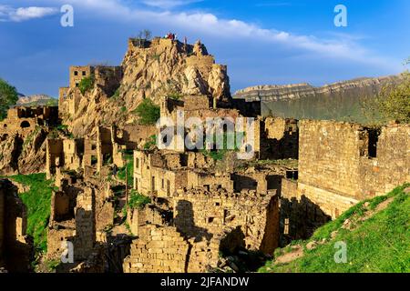 Gamsutl, Russia - 15 maggio 2022: Vista del villaggio abbandonato su una cima di montagna a Dagestan, con i turisti tra le rovine Foto Stock