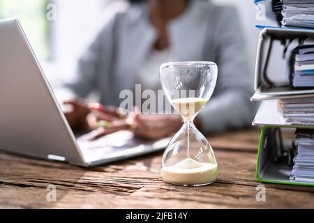 Black Accountant Woman lavora con fattura e clessidra Foto Stock