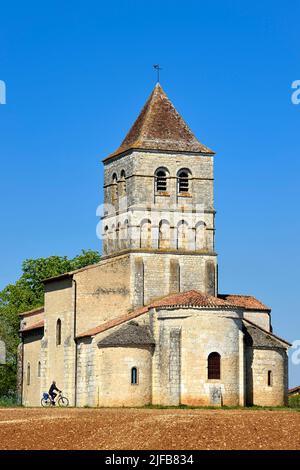 Francia, Dordogne, Périgord Vert, Javerlhac-et-la-Chapelle-Saint-Robert, ciclista viaggiando lungo la pista ciclabile Flow Vélo di fronte alla chiesa romanica di la Chapelle-Saint-Robert del 12th secolo, chiesa dell'ex priorato fondata da un discepolo del primo abate di la Chaise-Dieu Robert de Turlande Foto Stock