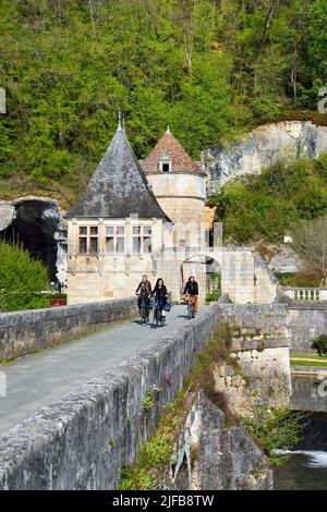 Francia, Dordogne, Brantome, Abbazia benedettina di Saint Pierre Pont Coude (ponte ad angolo) sul fiume Dronne, il padiglione rinascimentale e la torre che ha formato la porta fortificata sullo sfondo, ciclisti sulla pista ciclabile Flow Vélo Foto Stock