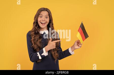 teen girl football fan. scelta direzione. stupito bambino punta dito sulla bandiera tedesca. Foto Stock