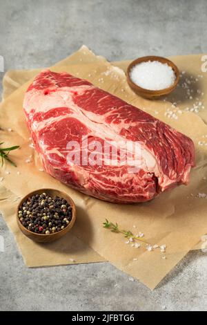 Erba biologica cruda alimentato Chuck Roast con sale e pepe Foto Stock