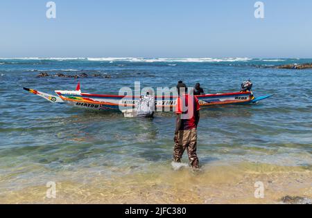 Dakar, Senegal. 18 agosto 2019: Pescatori con una barca da pesca in una spiaggia a Dakar, una delle molte spiagge di pesca di Dakar, Senegal, Africa occidentale Foto Stock